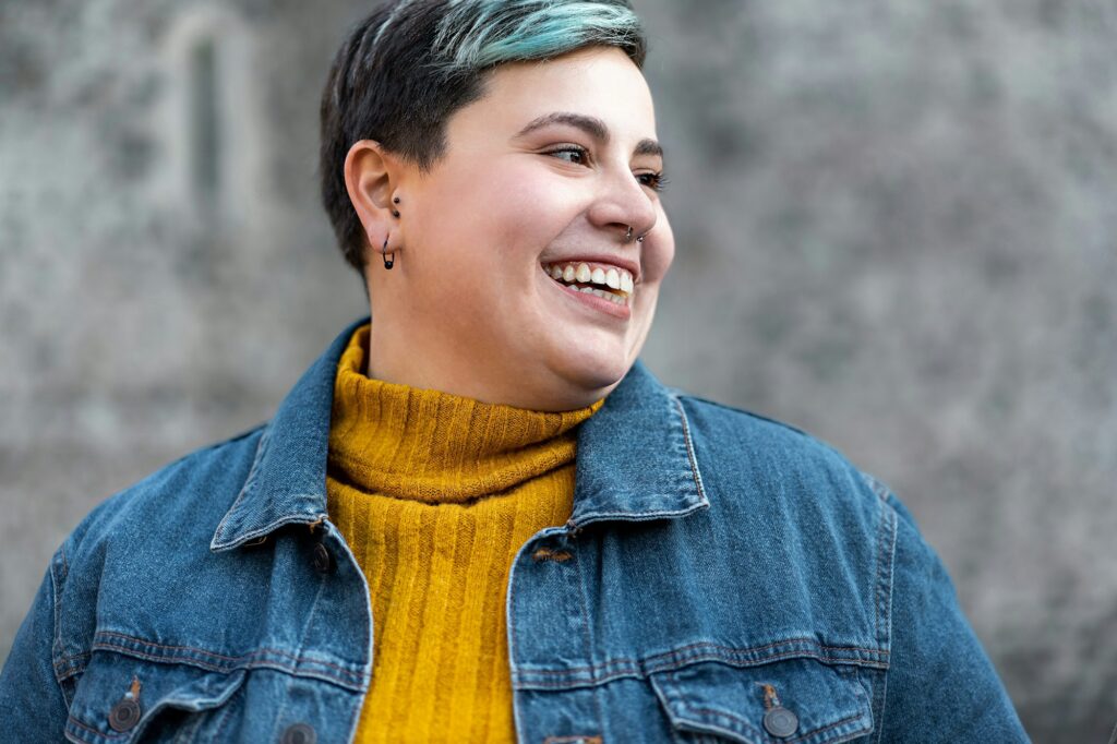 Portrait of a curvy gen z non binary woman with denim jacket